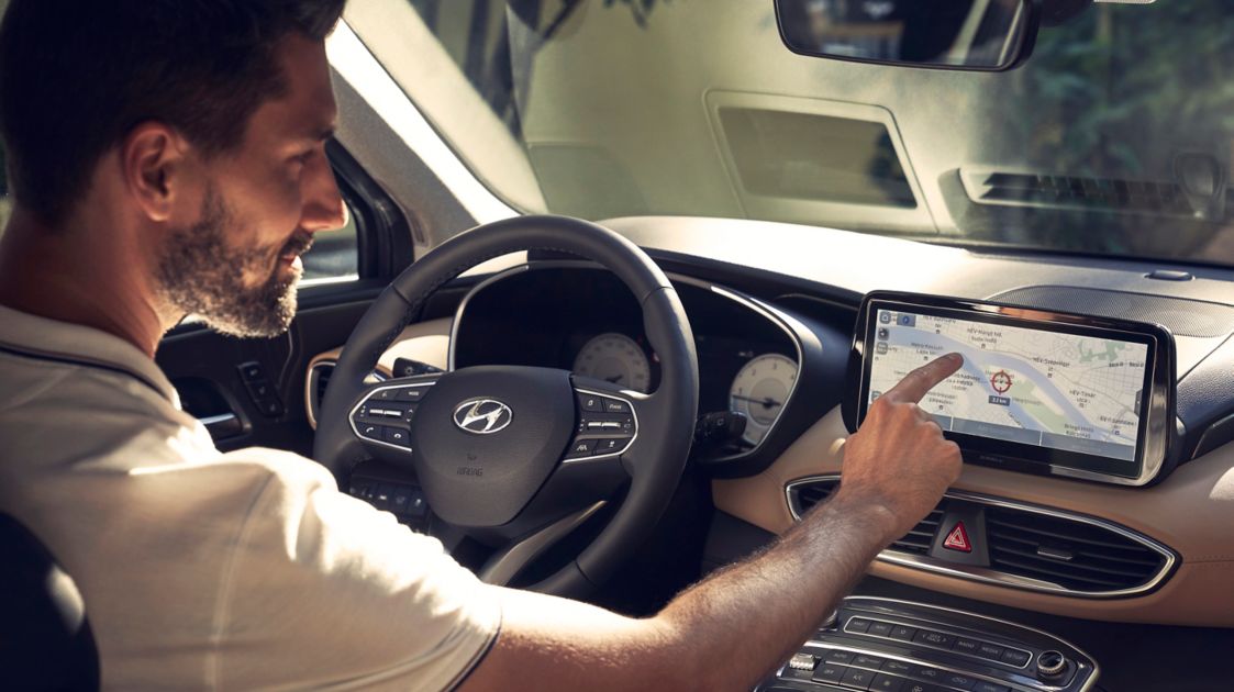 A driver of the new Hyundai SANTA FE Hybrid 7 seat SUV using the fully digital cluster.